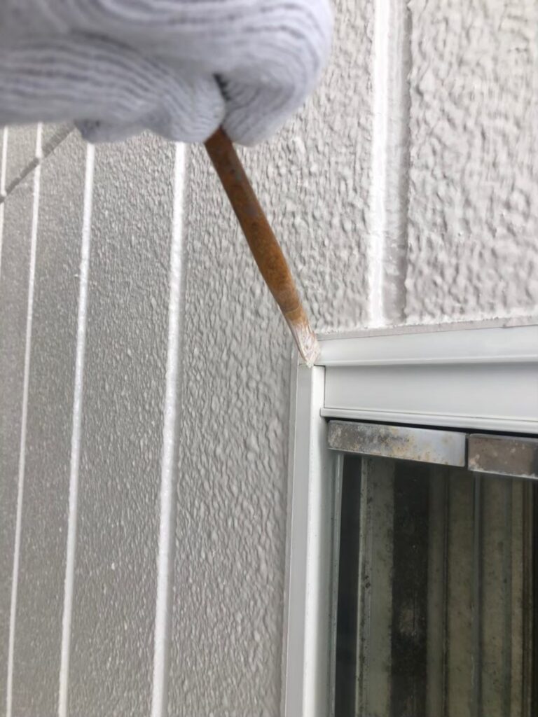ローラーで外壁を塗り重ねる塗装作業