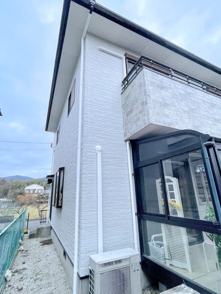 外壁塗装後の玄関まわりとグレーの石調デザイン