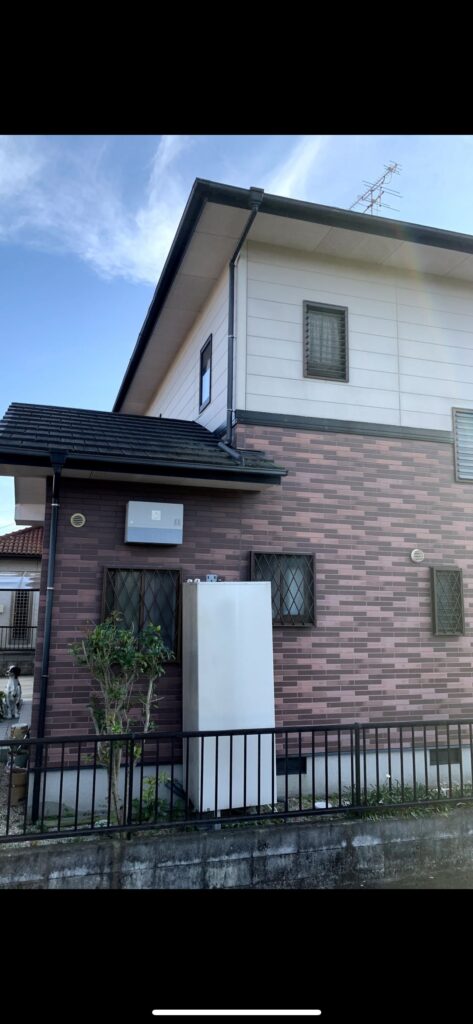 外壁塗装の施工前、赤茶系の外壁が使われていた建物側面