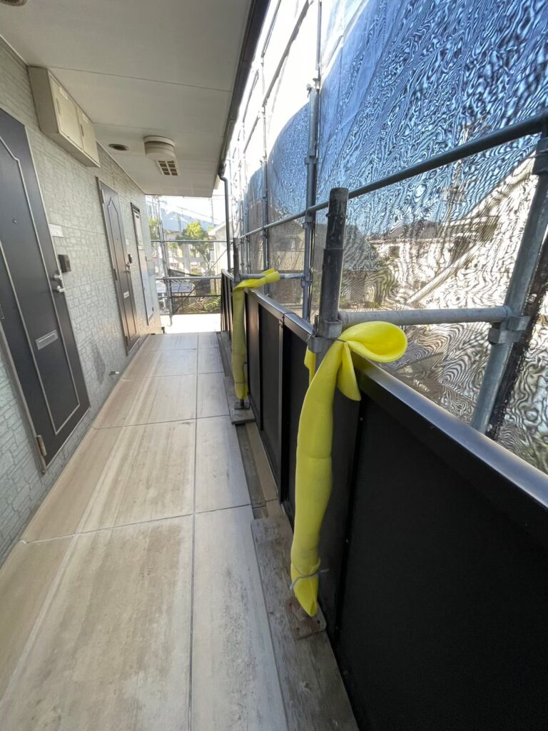 通路部分の足場支柱に緩衝材を巻いて安全配慮している様子