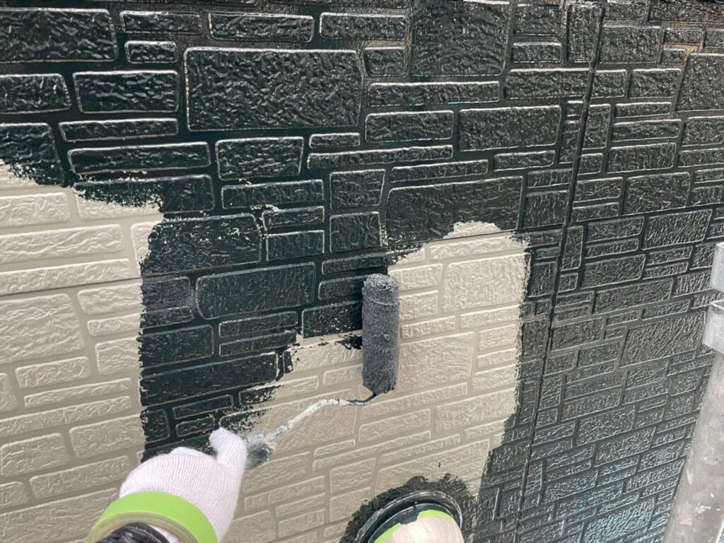 住宅の雨戸を吹き付けで塗装している施工風景