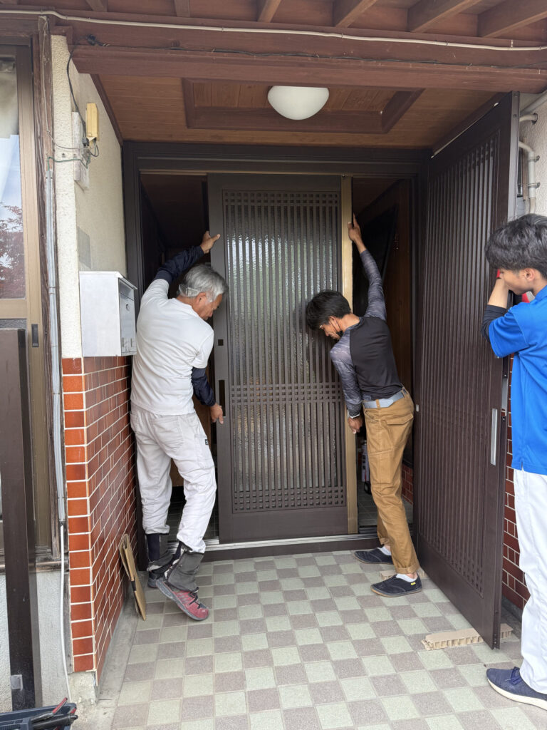 玄関引戸の位置を調整する施工スタッフ